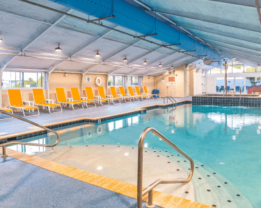 Indoor pool with accessible steps and yellow seating